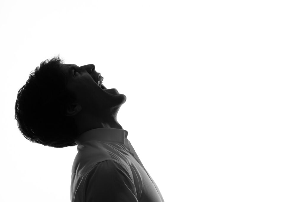 man silhouette angrily screaming shadow back lit white background