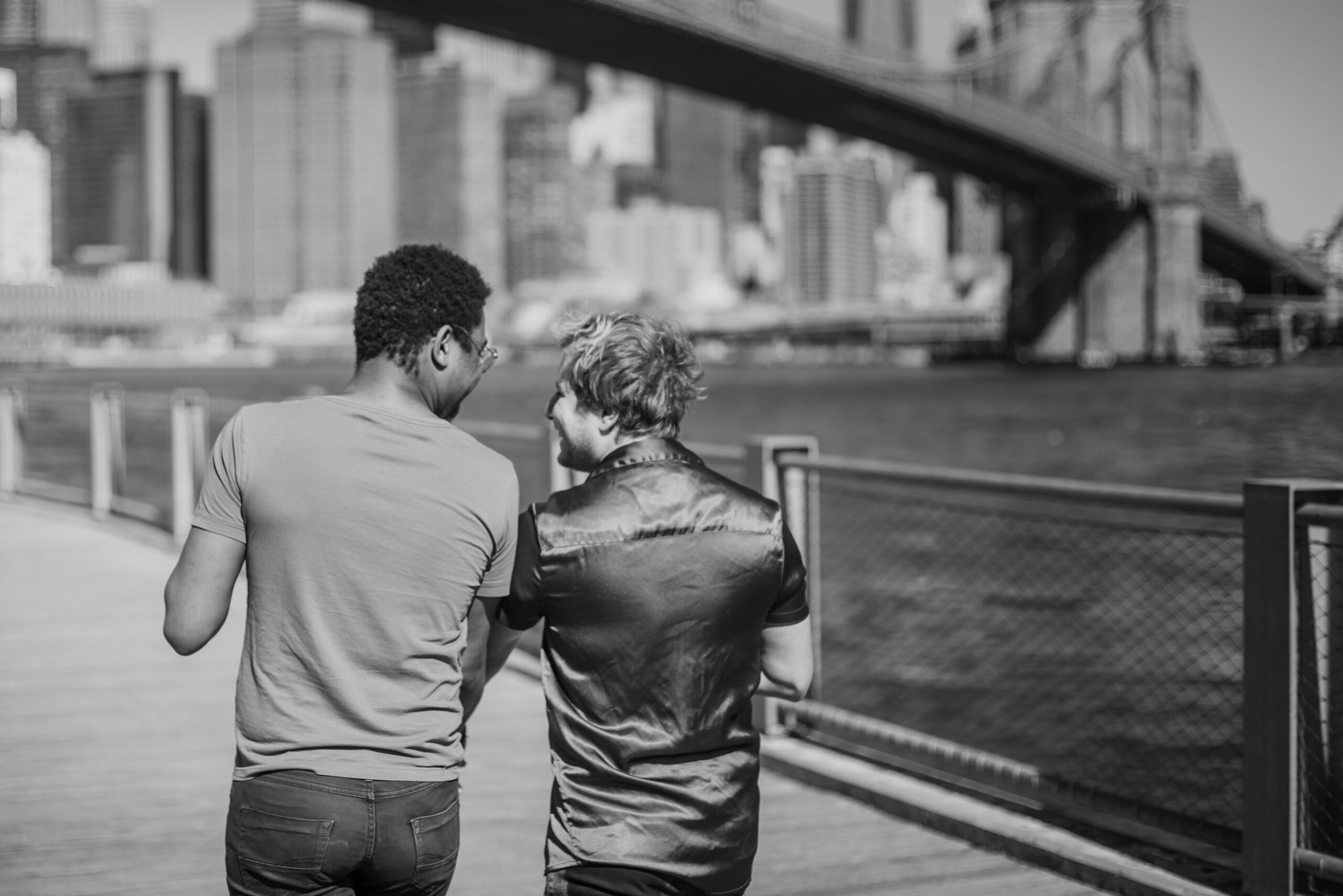 A loving couple walks together along a city waterfront, showcasing urban romance.